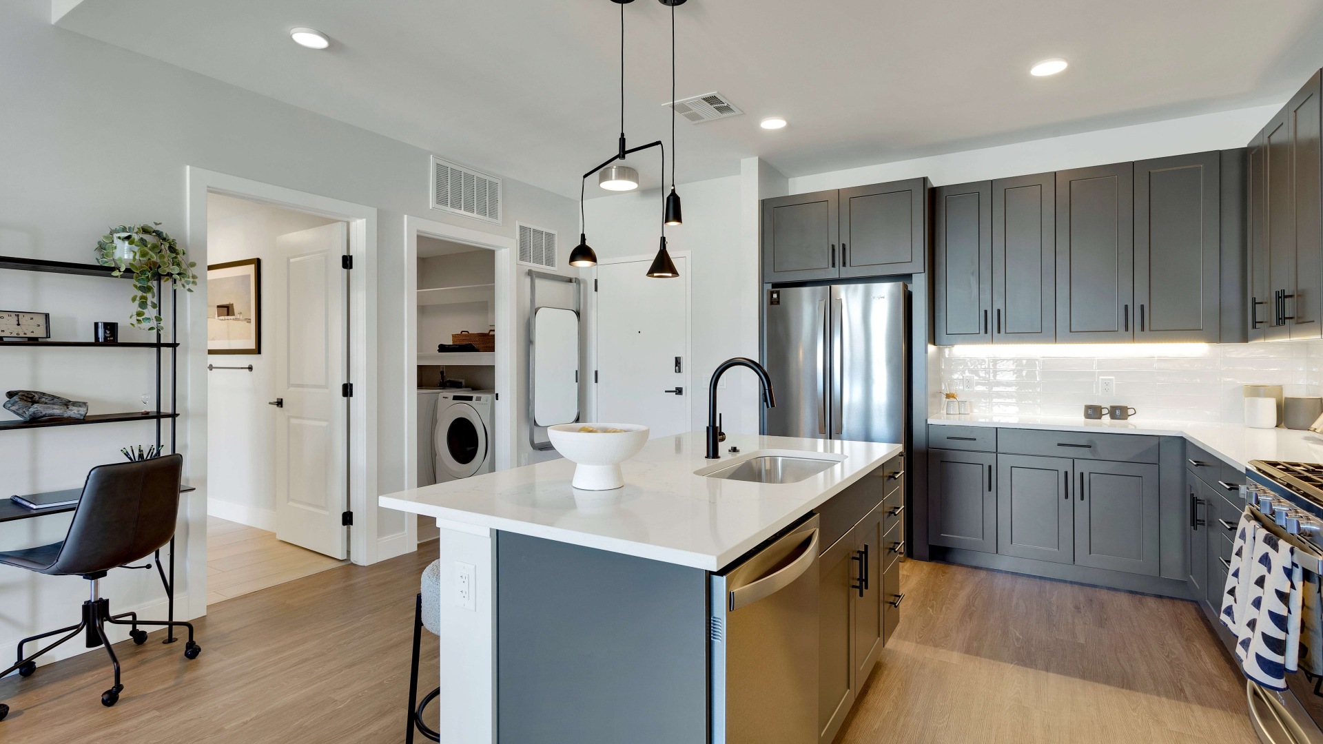 Modern kitchen with sleek dark cabinets, elegant pendant lighting, and a spacious island with integrated sink, offering a stylish workspace.	 Modern kitchen with sleek dark cabinets, elegant pendant lighting, and a spacious island with integrated sink, offering a stylish workspace.