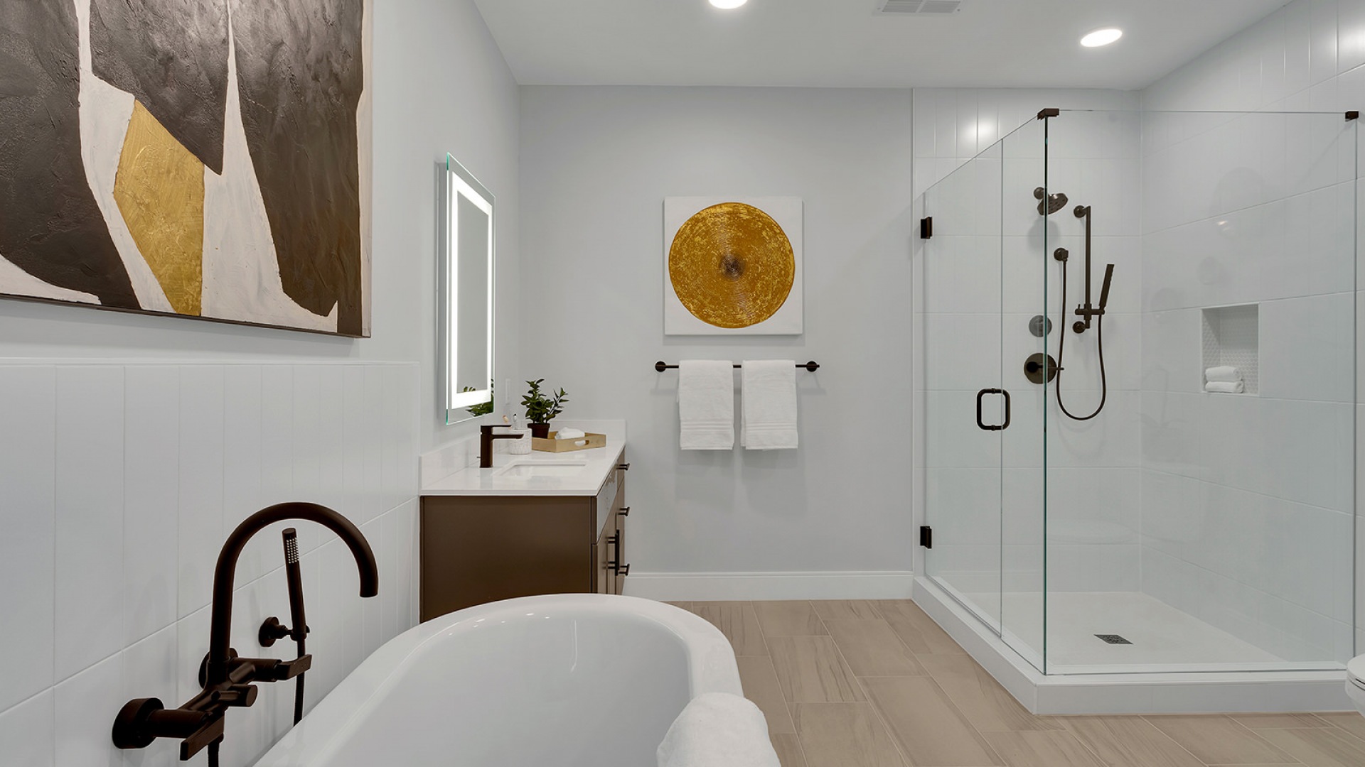 Modern bathroom with dual sinks and illuminated mirrors, flowing into a bright bedroom with large windows offering city views.	 Modern bathroom with dual sinks and illuminated mirrors, flowing into a bright bedroom with large windows offering city views.