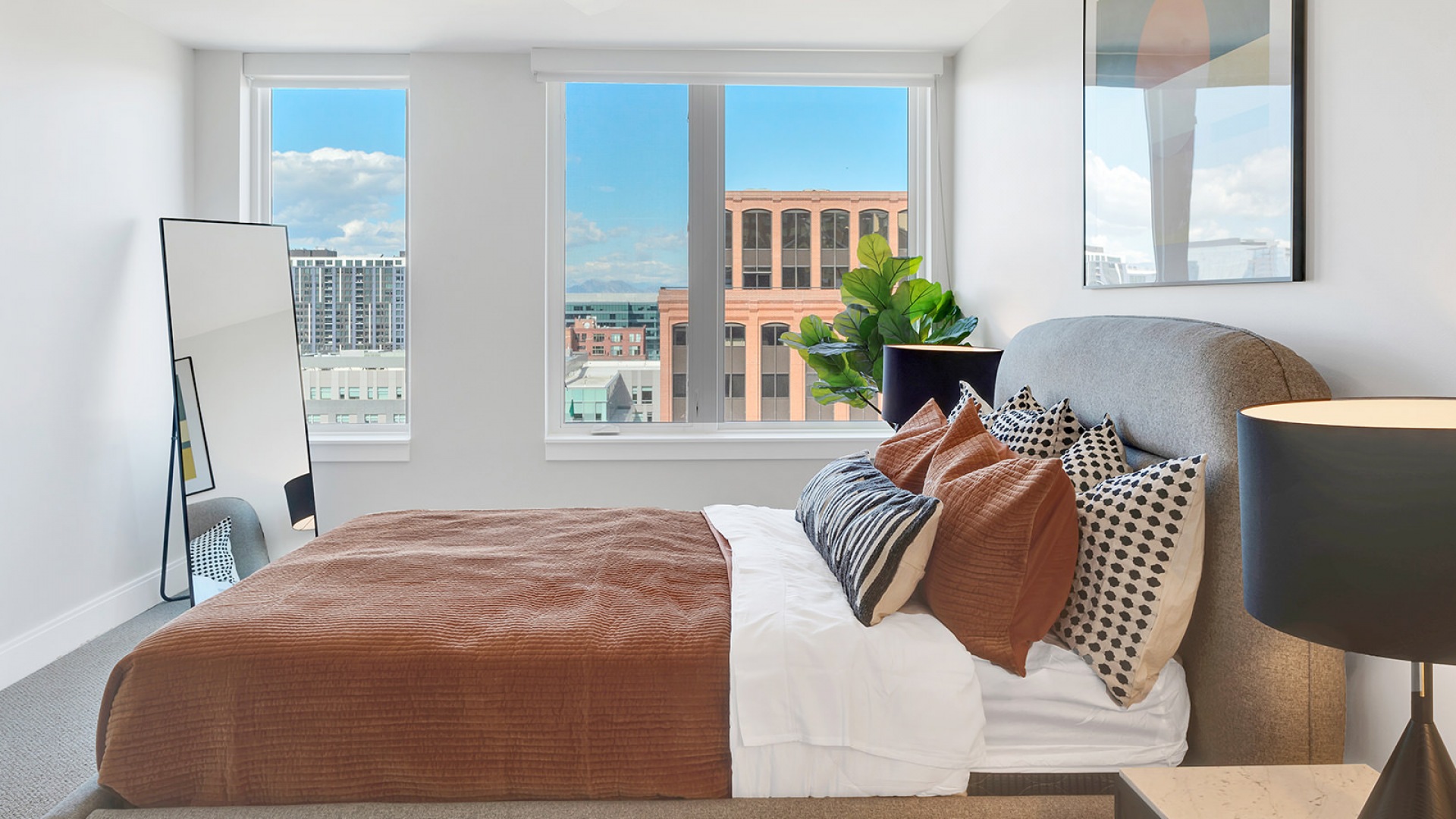 Bright and airy bedroom with a modern aesthetic, showcasing floor-to-ceiling windows with a stunning city view, stylish decor, and plush bedding for a cozy, inviting atmosphere.	 Bright and airy bedroom with a modern aesthetic, showcasing floor-to-ceiling windows with a stunning city view, stylish decor, and plush bedding for a cozy, inviting atmosphere.