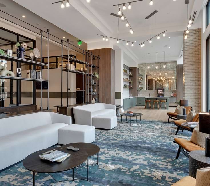 Elegant open-concept living space with modern furnishings, statement lighting, and floor-to-ceiling windows overlooking urban scenery.	